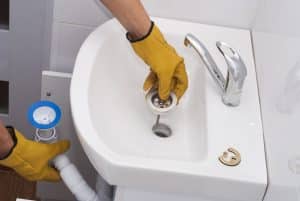 plumber installs a new plastic siphon on the sink